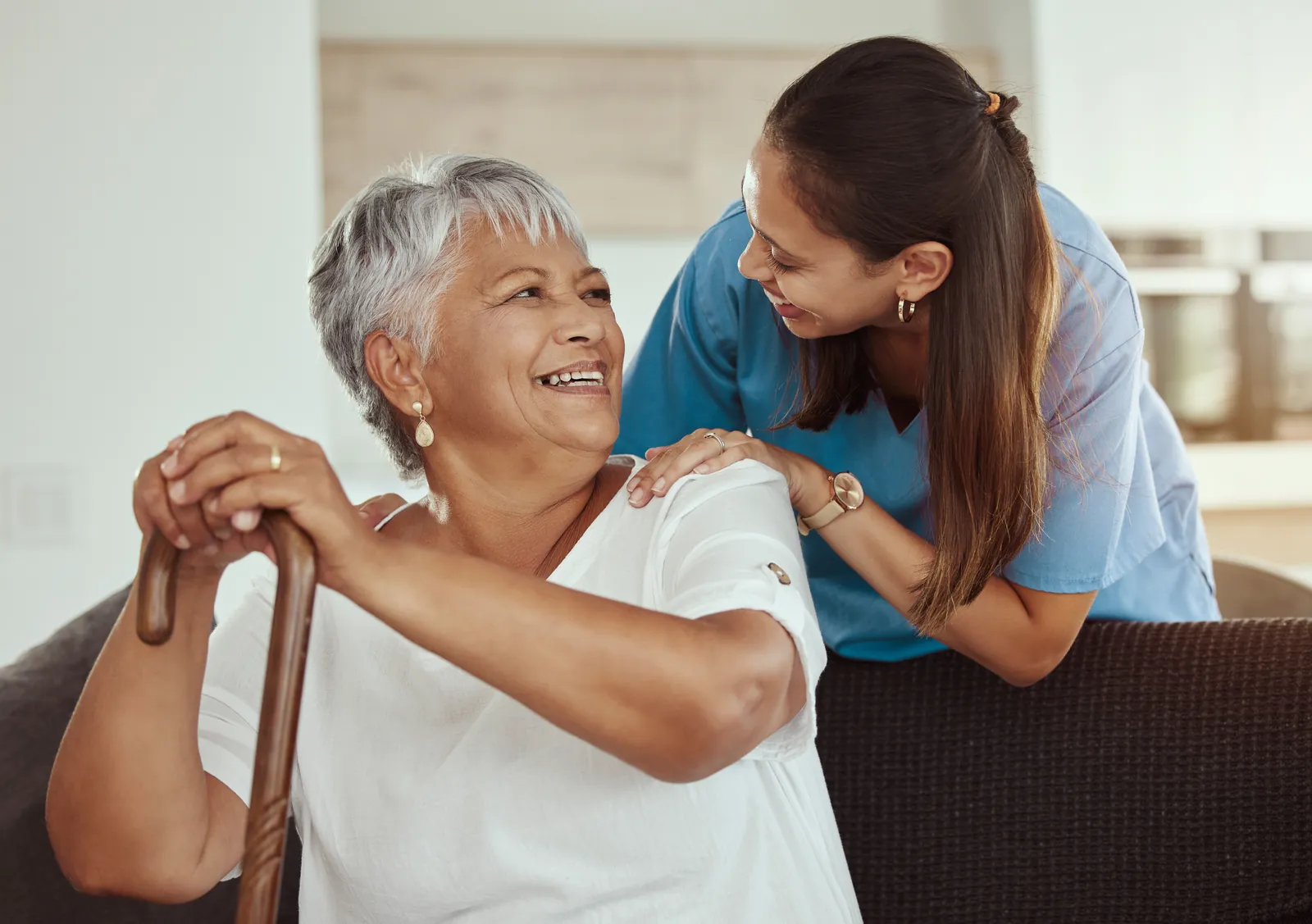 Carer and elderly woman enjoying a cup of tea together