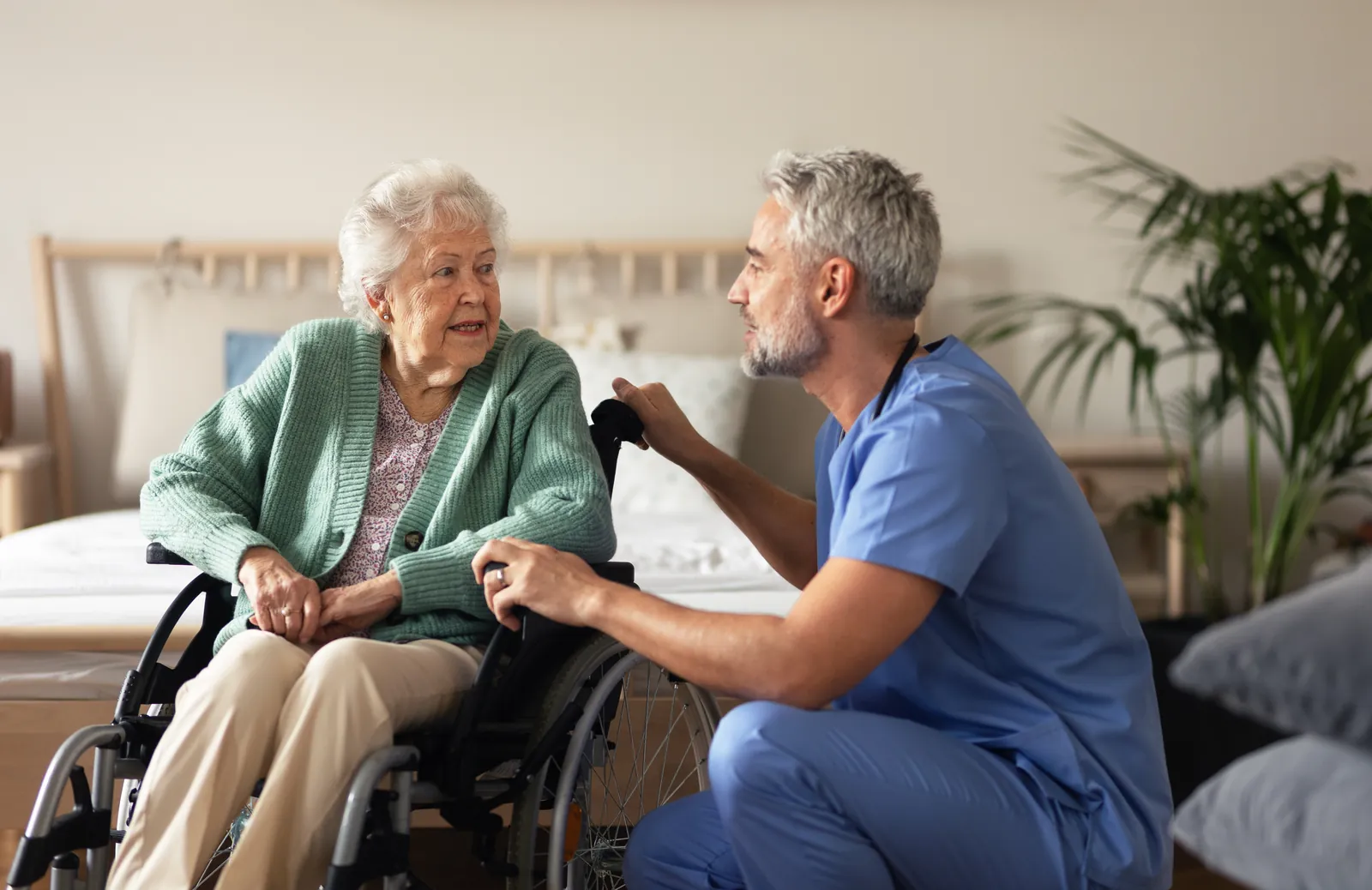 Carer sitting with an elderly woman as they talk over tea